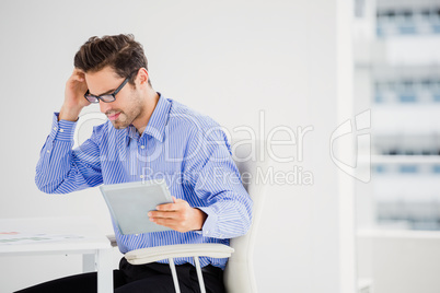 Businessman looking at document and using digital tablet