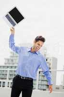 Frustrated businessman throwing laptop