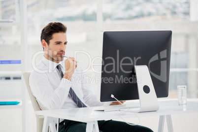 Businessman using computer and taking notes