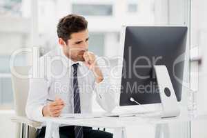 Businessman using computer and taking notes