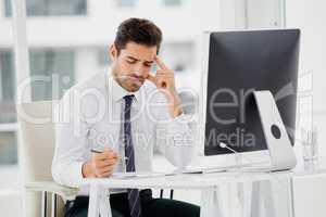 Businessman using computer and taking notes