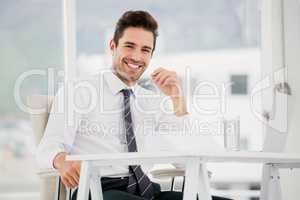 Businessman using laptop and taking notes