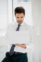 Businessman using laptop and taking notes