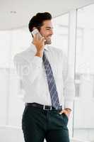 A businessman is calling and looking outside