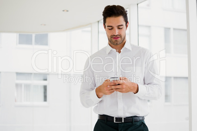 A businessman is holding his smartphone and texting