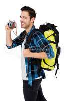 Young man carrying rucksack and using camera