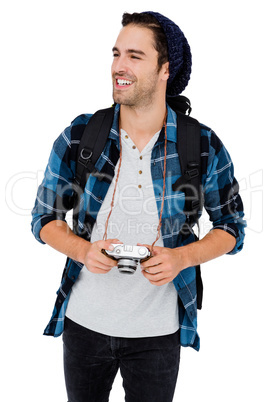 Young man carrying rucksack and holding camera