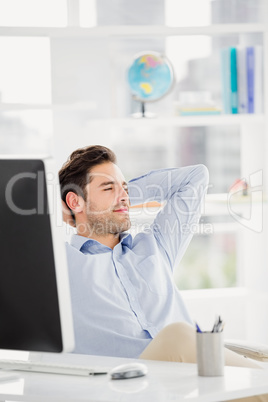 Businessman sitting with hands behind head in the office
