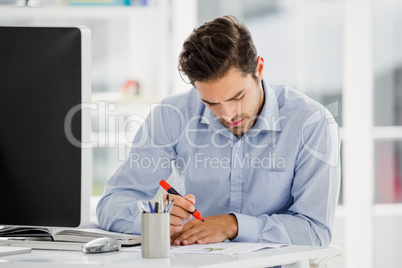 Businessman taking notes at his desk Businessman taking notes at his desk