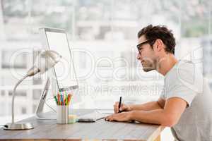 Young man using pen tablet and computer