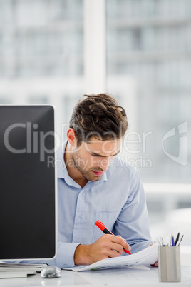 Businessman taking notes at his desk