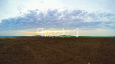 Ploughed Land and Clouds. Panorama. Time Lapse