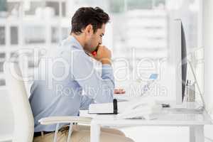 Businessman reading document at his desk