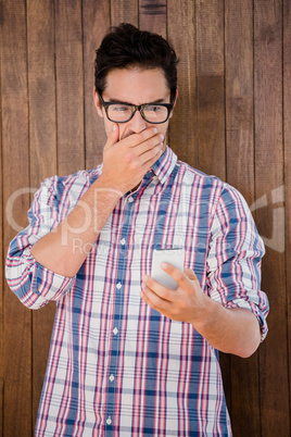 Shocked young man looking at mobile phone