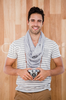 Smiling man standing with a camera