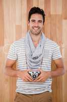 Smiling man standing with a camera