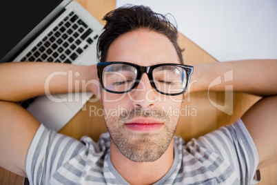 Man in spectacles sleeping on the floor with laptop