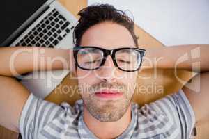 Man in spectacles sleeping on the floor with laptop