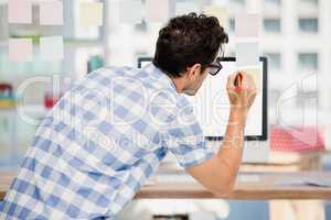 Rear view of man writing on sticky notes