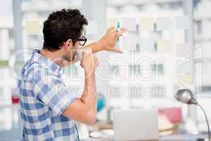 Man reading at sticky notes while having coffee