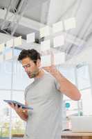 Man looking at digital tablet and sticky notes