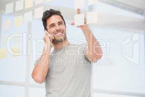 Man looking at a sticky notes while talking on phone