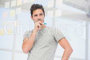 Thoughtful man looking at sticky notes on window