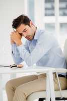 Tensed businessman sitting at table