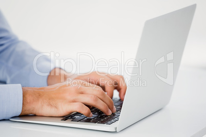 Mid-section of businessman working on laptop