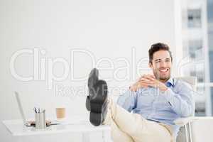 Thoughtful man sitting with feet on table