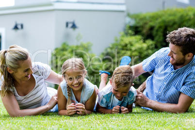 Happy parents tickling children in yard