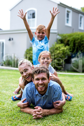 Boy with arms raised with family in yard