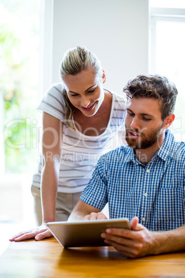 Man showing digital tablet to woman at home Man showing digital tablet to woman at home