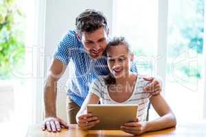 Smiling man and woman looking at digital tablet