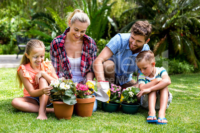 Happy family with flower pots at yard