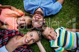 Happy family lying on grass at yard