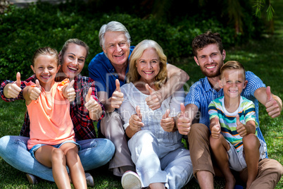 Potrait of family gesturing thumbs up at yard