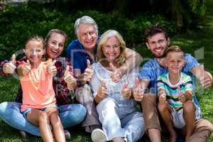 Potrait of family gesturing thumbs up at yard