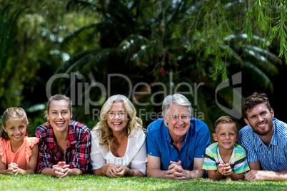 Portrait of family lying on grass at yard