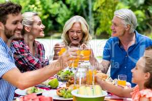 Smiling family toasting juice at table