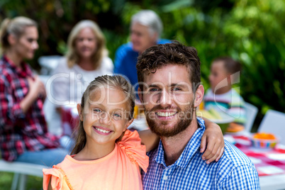 Father carrying daughter with family at yard