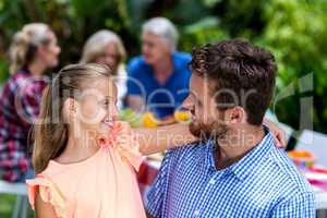 Father looking at daughter in yard