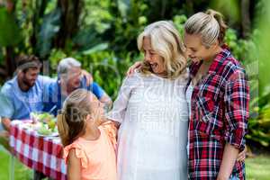 Happy mother and granny looking at girl in yard