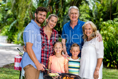 Happy family grilling food in barbeque at yard
