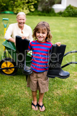 Boy with wellington boots while standing in yard