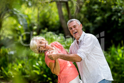 Senior couple enjoying while dancing in yard