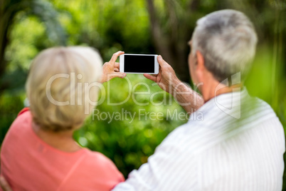 Senior couple taking selfie in yard