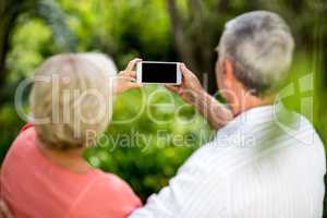 Senior couple taking selfie in yard