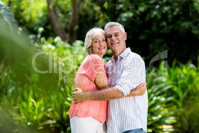 Smiling senior couple embracing at yard