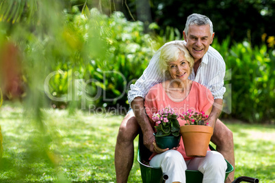 Senior couple with flower pots in yard